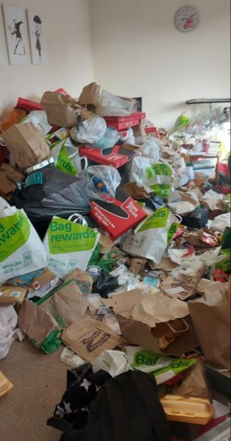 A large pile of trash bags and packaging in a room.