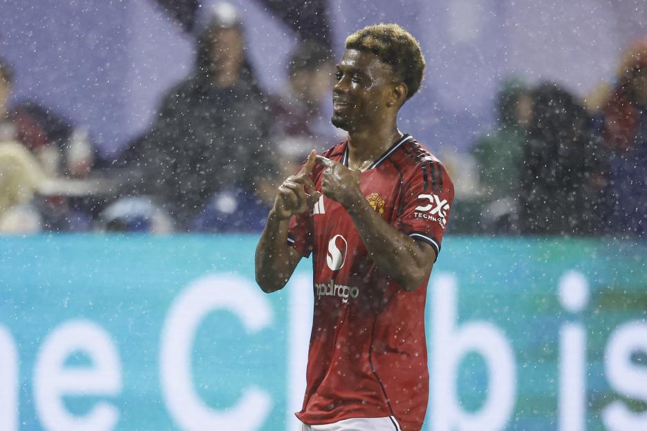 Amad Diallo of Manchester United celebrates scoring a goal in the rain.