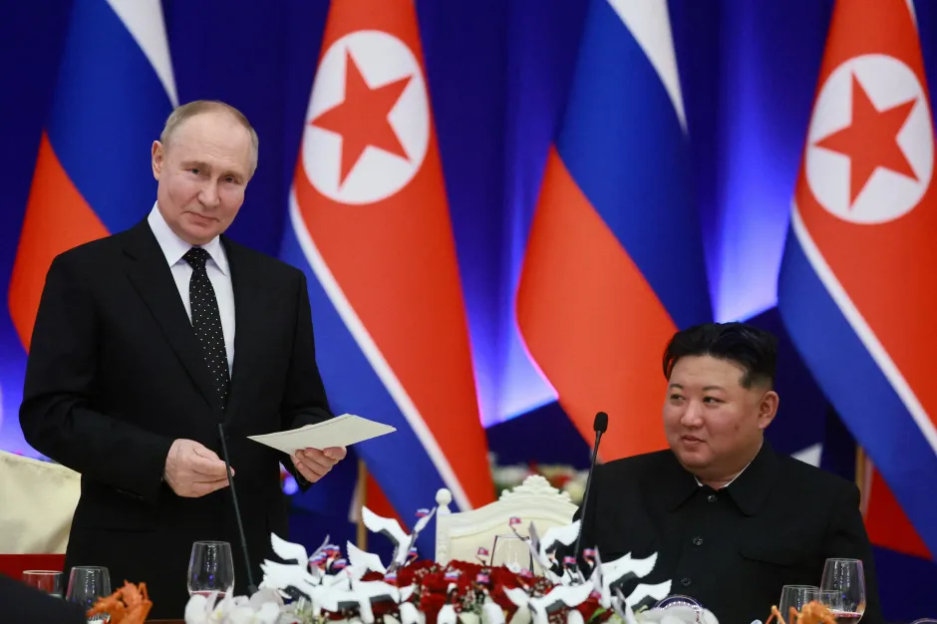 Vladimir Putin and Kim Jong-un seated at a table.
