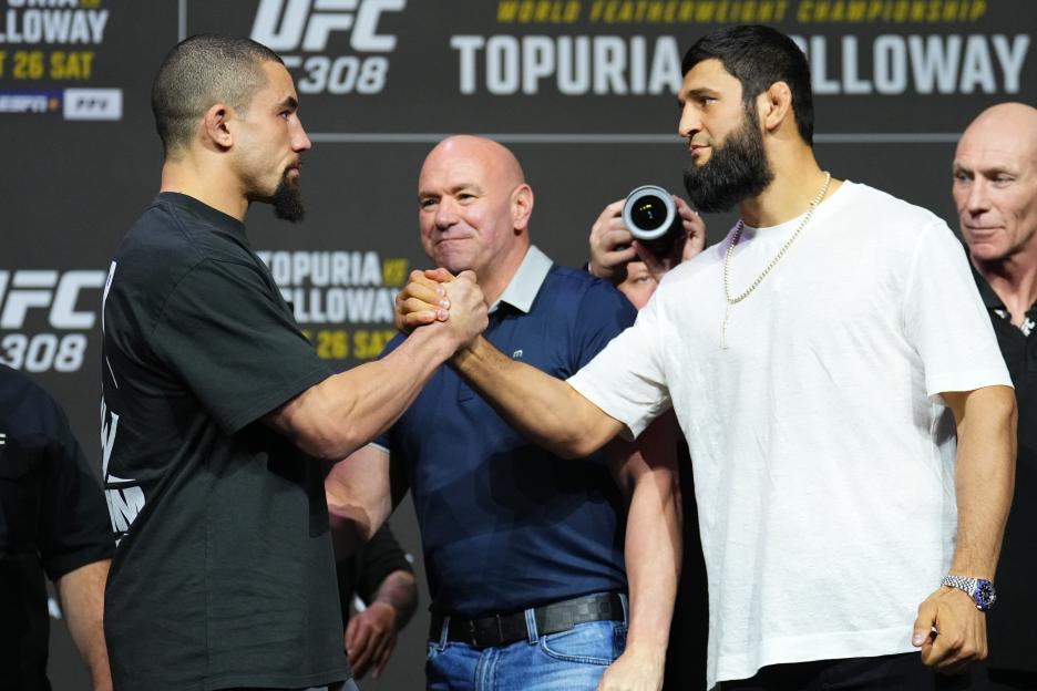 Robert Whittaker and Khamzat Chimaev shaking hands at a press conference.