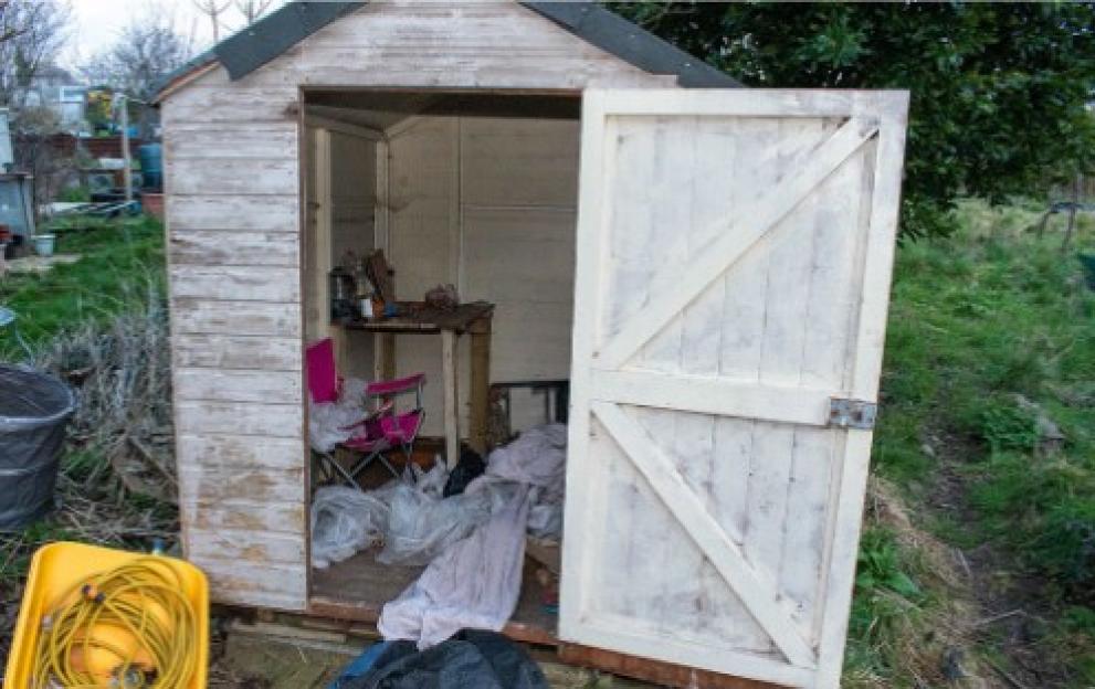Messy allotment shed with camping chairs and blankets inside.