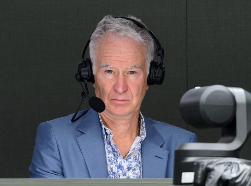 a man wearing a suit and headphones looks at the camera