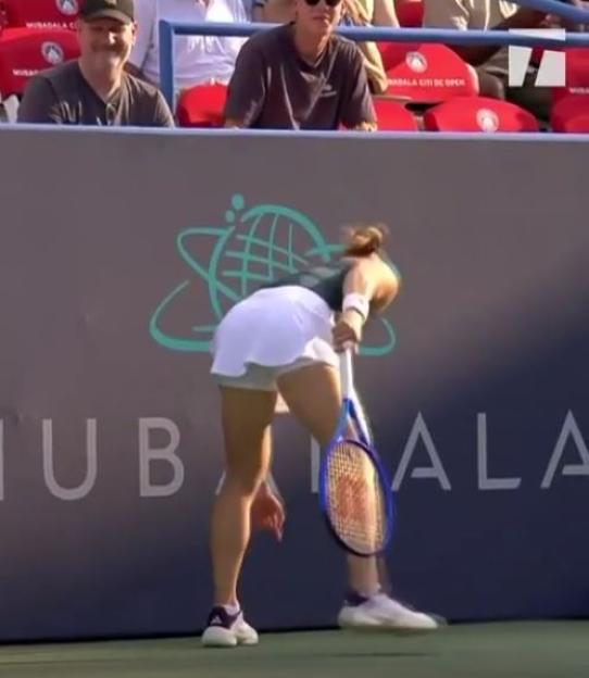 Tennis player bending over with a tennis racket.