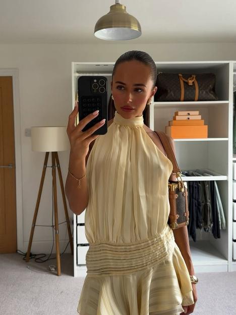 Woman taking a selfie in a pale yellow striped dress.