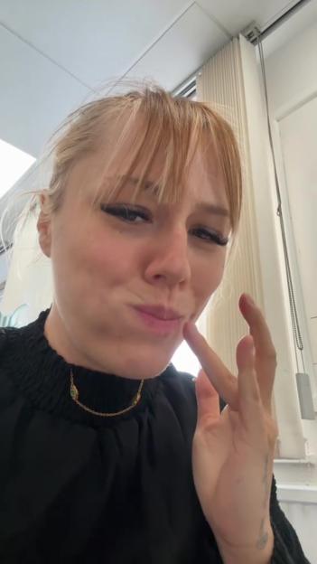 Close-up of a woman touching her face.