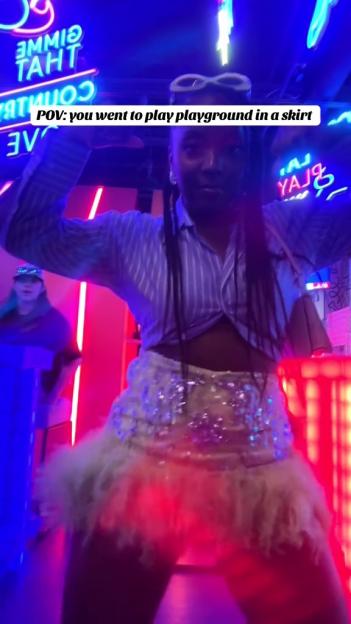 Person in a sparkly skirt at a carnival.