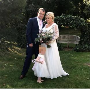 Wedding photo of a bride and groom with a child.