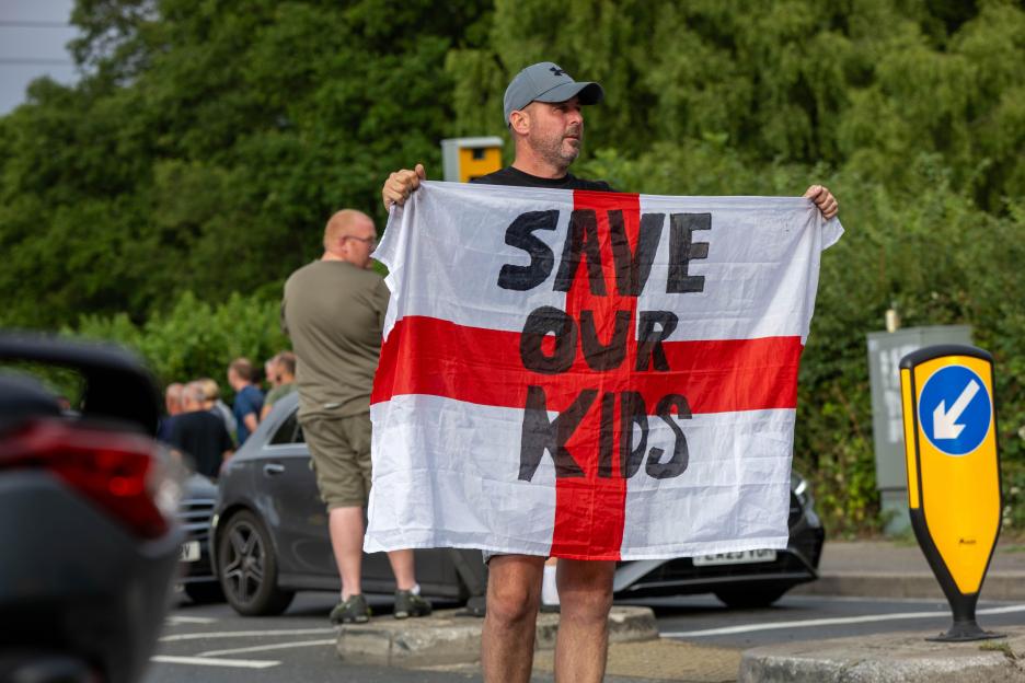 Protestor holding a flag that says 