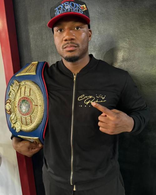 Boxer holding championship belt.