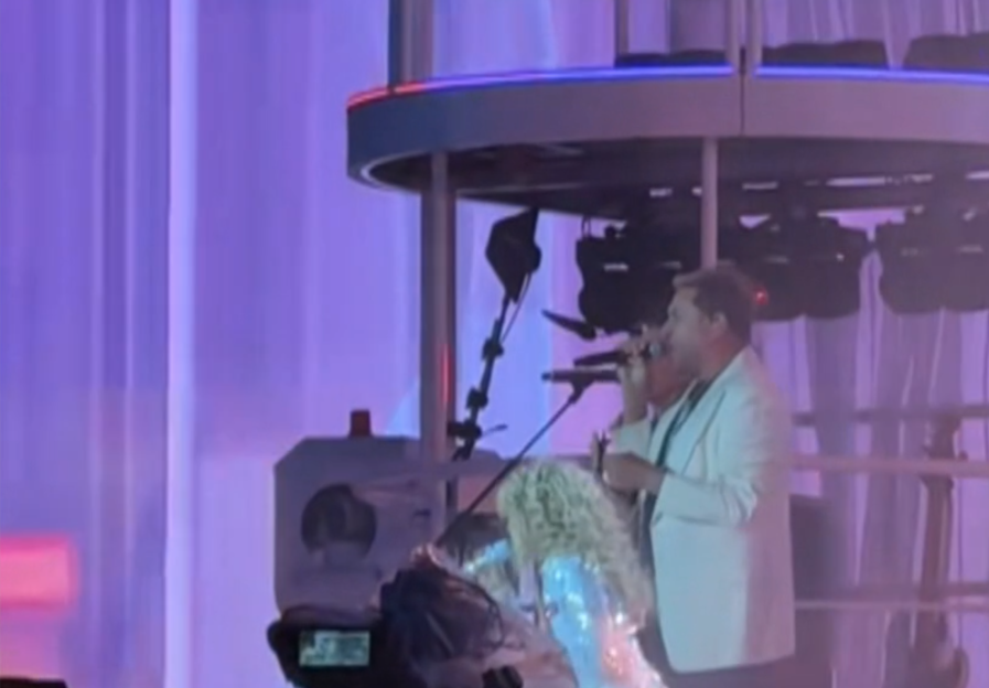 Sabrina Carpenter and a man in a white suit performing on stage.