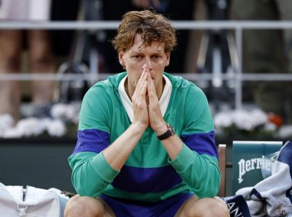 Jannik Sinner looking dejected after losing a tennis match.