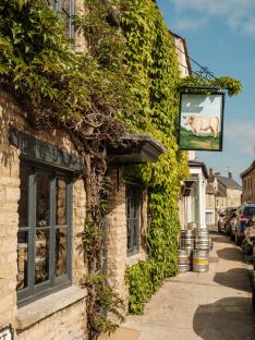 Ivy-covered building with a pub sign depicting a bull.