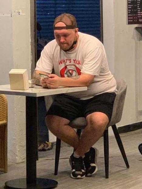 Man sitting at a table looking at his phone.
