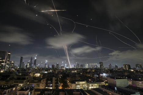Iron Dome air defense system intercepting missiles over Tel Aviv at night.