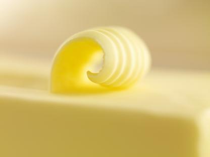 Close-up of a curl of butter on a stick of butter.