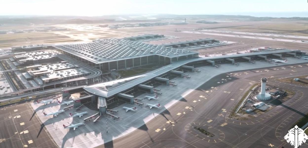 Aerial view of a modern airport terminal with airplanes parked at gates.