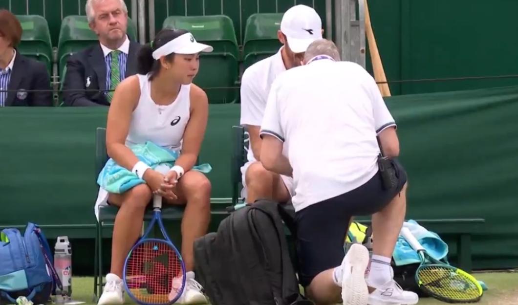 Tennis player receiving medical attention on the court.