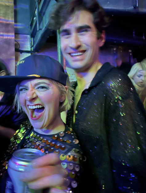 Two people smiling, one holding a can.