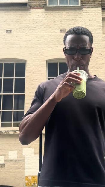 A man drinking a green smoothie.