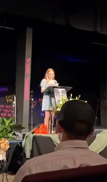 Teen girl delivering a eulogy at a funeral.