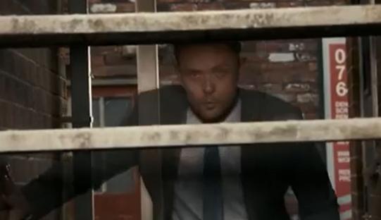 Man seen through a metal railing.