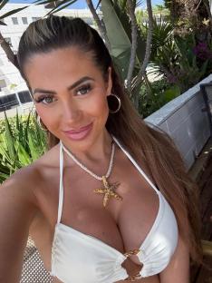 Woman in white bikini wearing a starfish necklace.