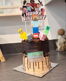 Two-tiered Minecraft birthday cake with figurines.