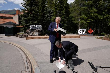 Keir Starmer picking up papers dropped by Donald Trump at the G7 summit.