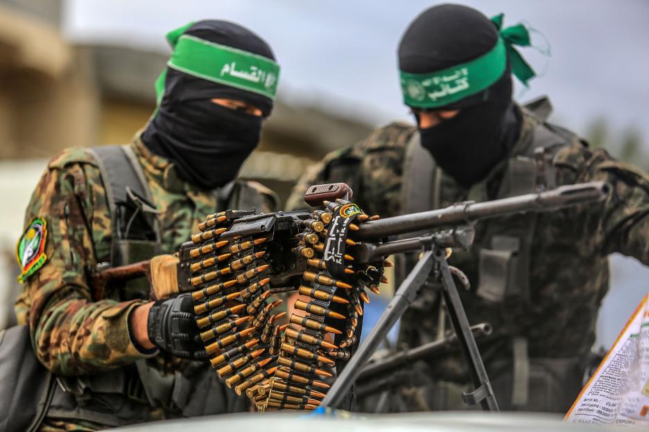 Hamas fighters with a machine gun and ammunition belt during a prisoner exchange.
