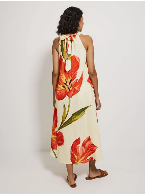 Woman in a halter neck maxi dress with a large tulip print.