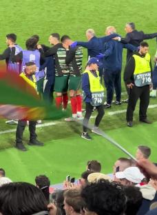 Portugal players huddle together on the soccer field after a penalty shootout.
