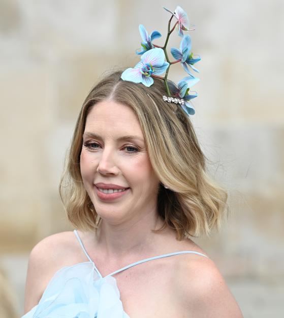 Woman with blond hair and blue orchids in her hair.