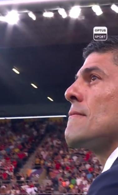 Close-up of a man watching a crowded stadium.