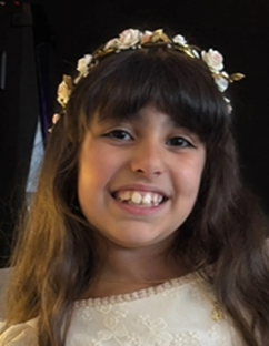 Smiling girl wearing a flower crown and white dress.
