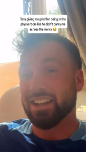 Man in a blue shirt smiling and talking about Tony.