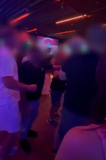 Blurry photo of a fight breaking out in a nightclub.