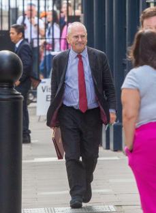 Minister Peter Hendy walking down a street.
