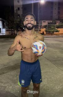 Shirtless soccer player holding a soccer ball.
