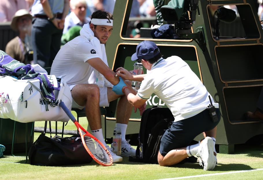 Taylor Fritz receiving medical treatment at Wimbledon.