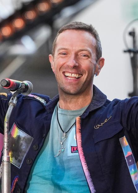Chris Martin smiling at a microphone.