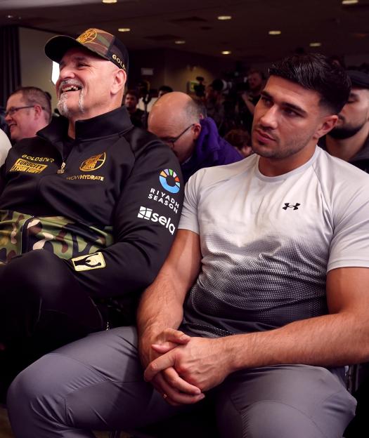 John Fury and Tommy Fury seated in an audience.