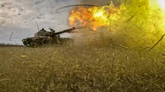 British Challenger 2 tank firing in a field.