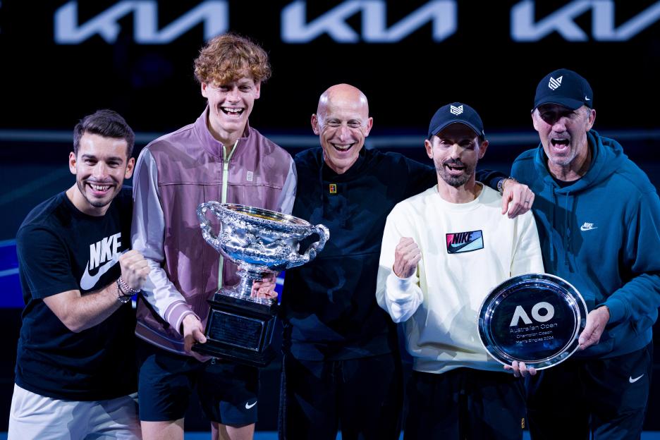 Jannik Sinner and his team posing with trophies after winning the Australian Open.