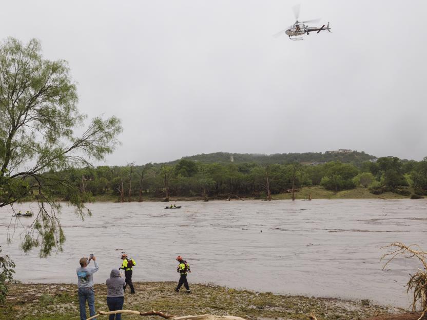 Texas DPS helicopter conducting aerial searches over a flooded river.