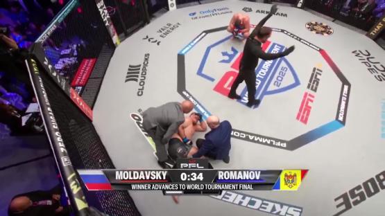 A mixed martial arts fighter lies on the mat after a match, attended to by medical personnel.