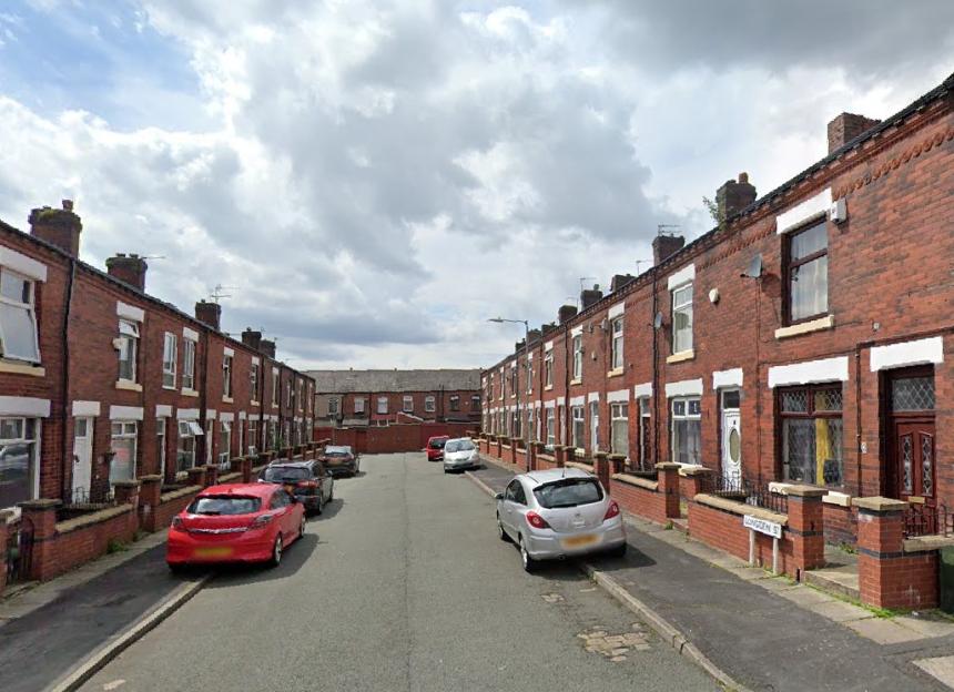 Longden Street in Bolton, showing terraced houses and parked cars.