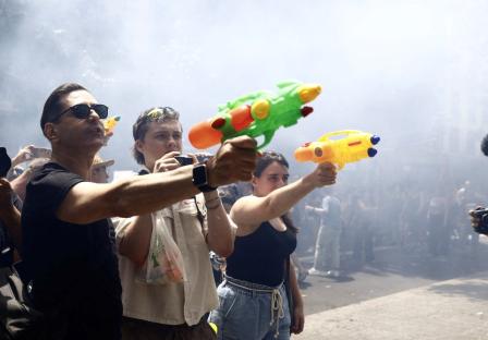 People using water guns during a protest.