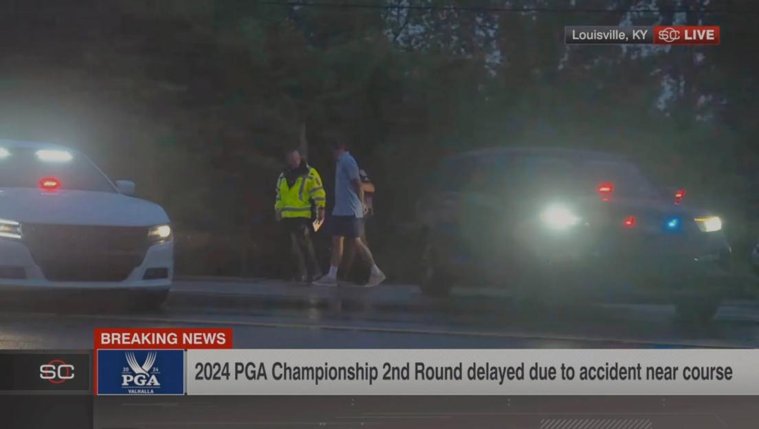 Still image from video showing Scottie Scheffler being escorted by police after an accident near Valhalla Golf Club.