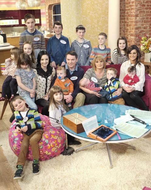 The Radford family, including parents Sue and Noel, and many of their children, on a TV program.