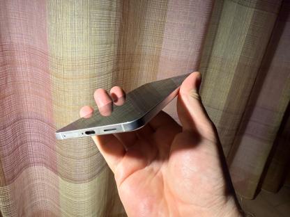 A hand holding a silver smartphone.